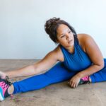 woman in blue activewear stretching