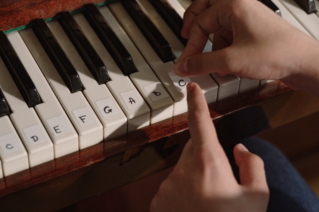 person sticking an adhesive tape on piano keys