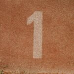 Close-up image of number one lane on a running track, symbolizing first place.